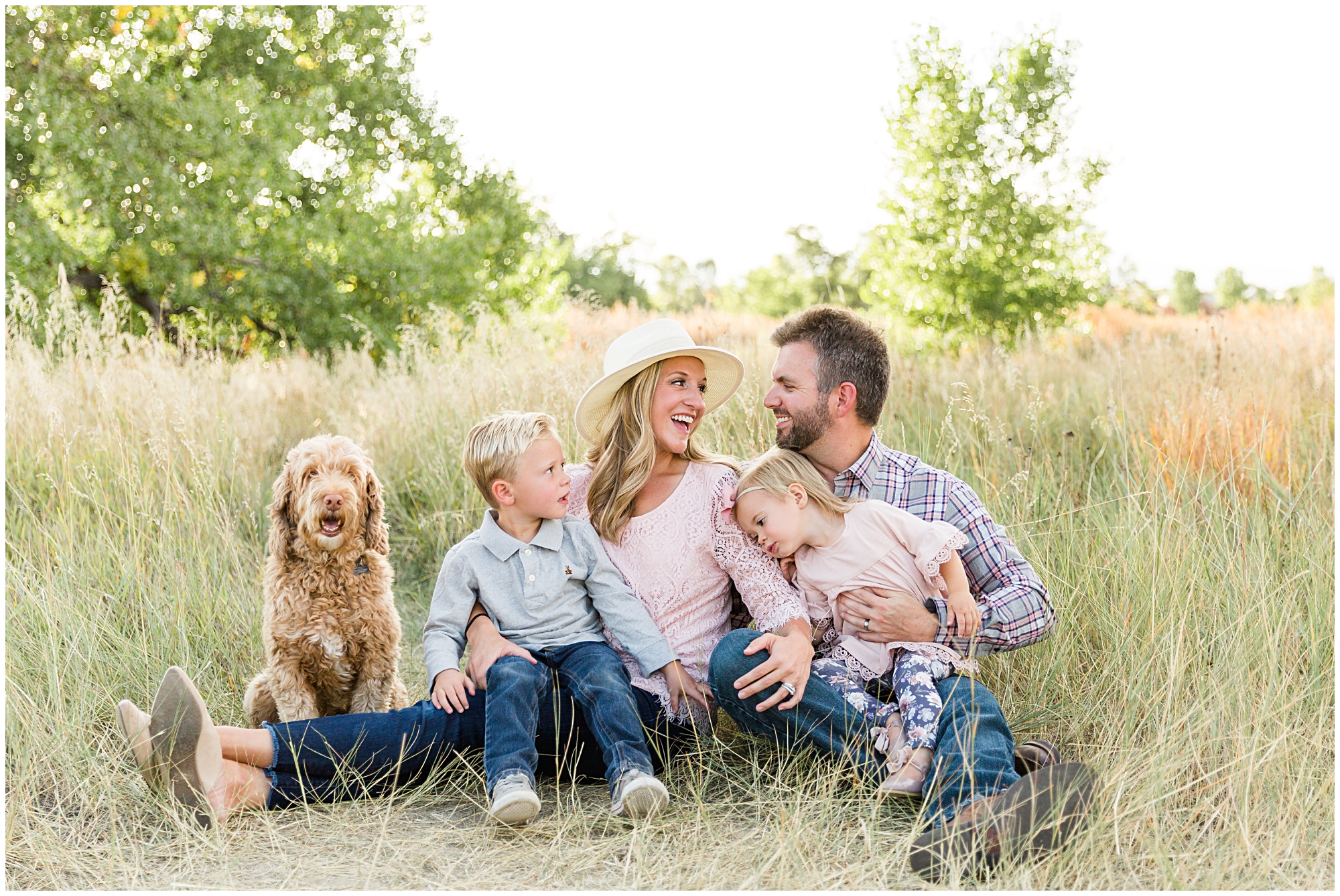 Photo of a young family laughing together during an outdoor mini photography session in Erie Colorado