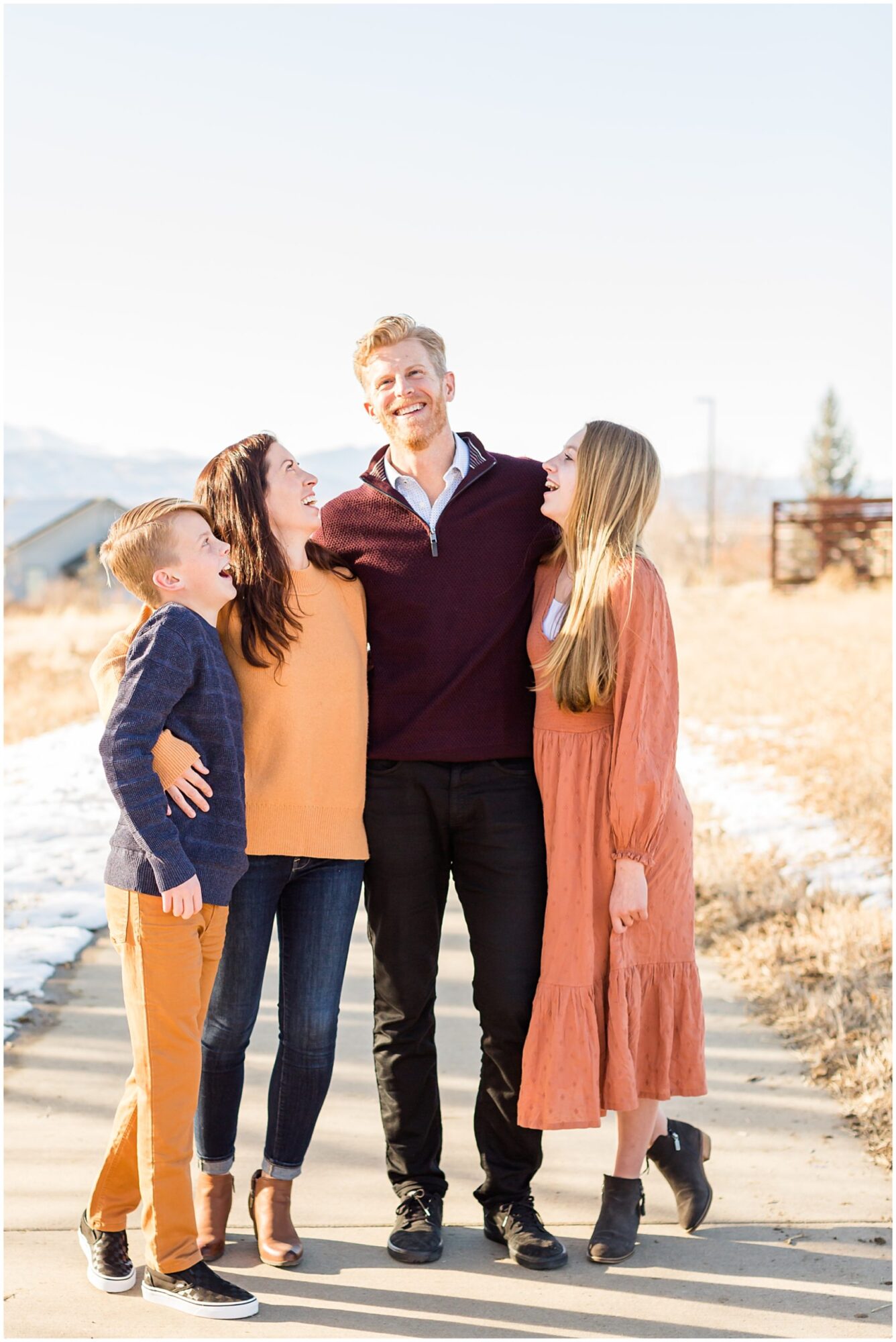 A family with two teenagers laughing together during an outdoor family session in Erie Colorado