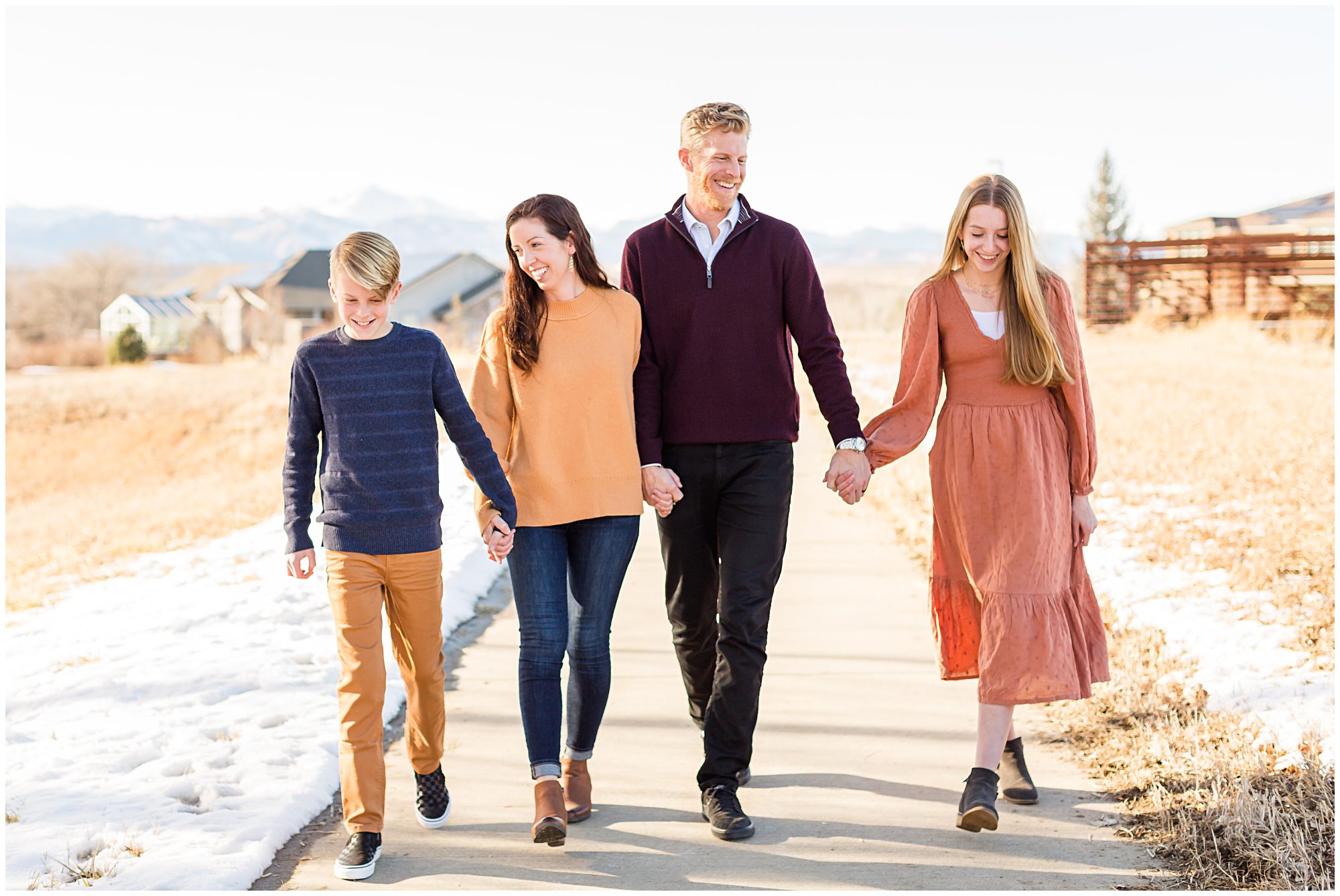 A family with two teenagers walking together along a trail during an outdoor family session in Erie Colorado