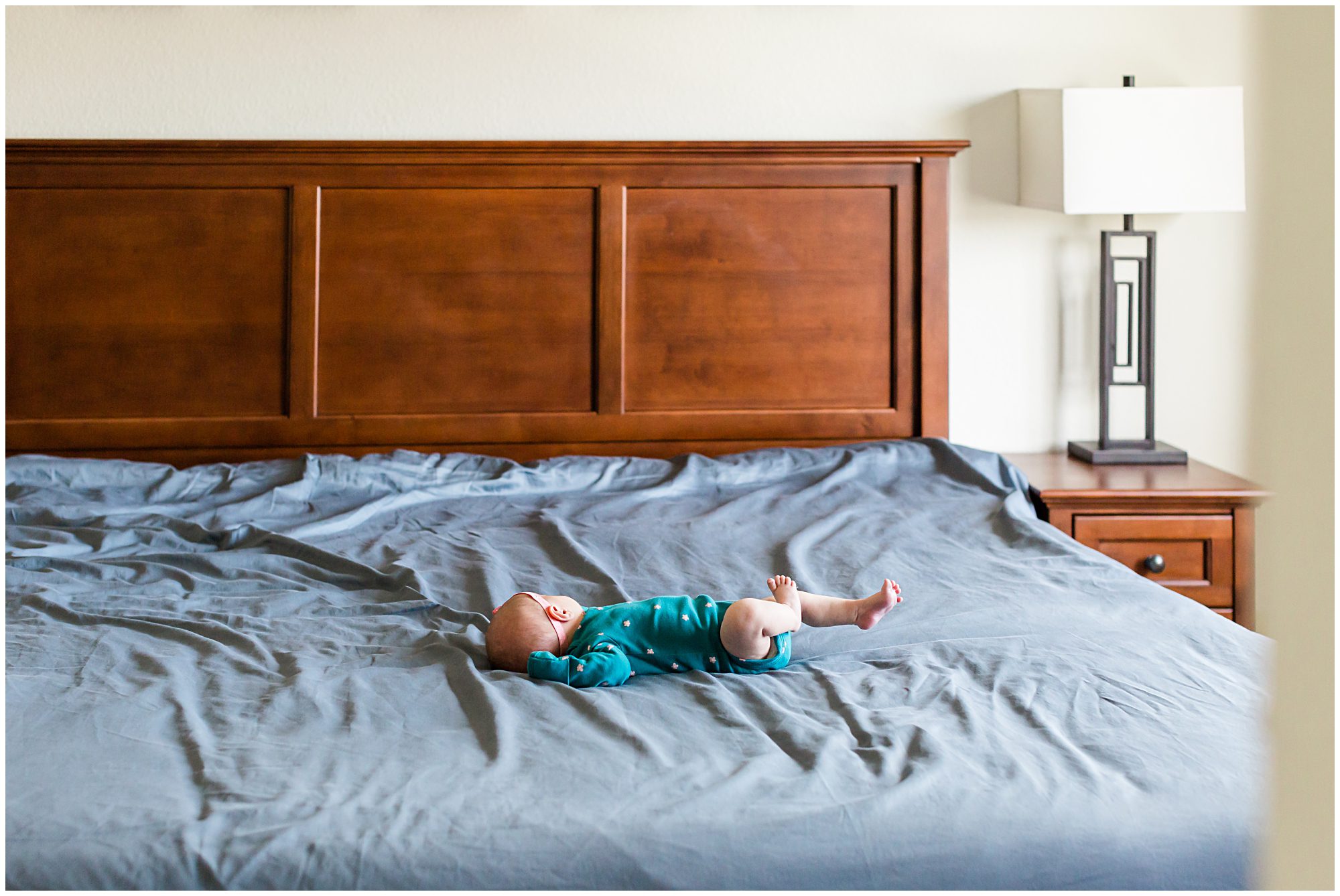 A newborn baby girl sleeping on her parents' bed