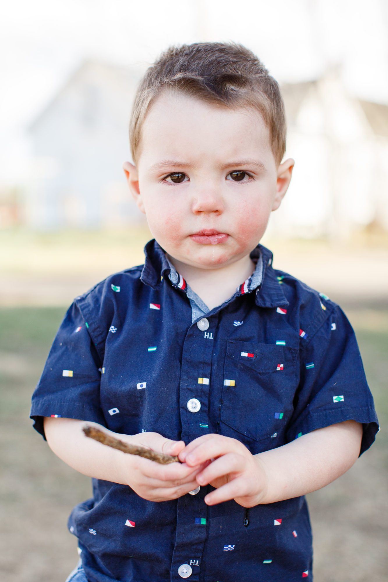 A serious little boy looks at the camera during his first family photo session in Erie Colorado