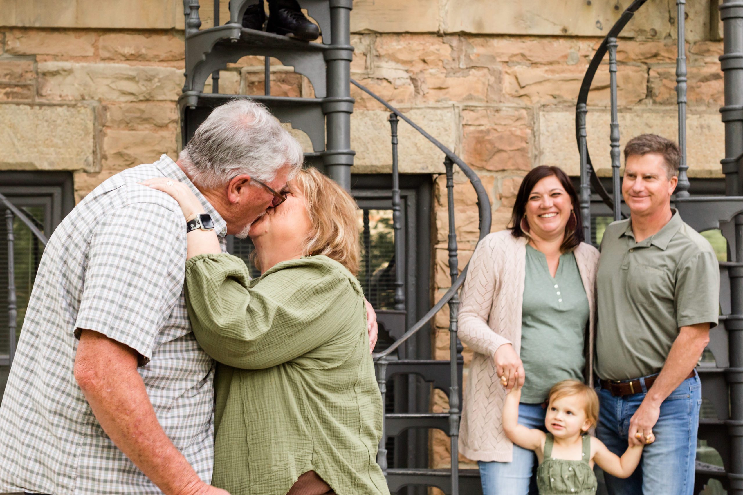 A mother and father celebrating their 38th wedding anniversary kiss in front of their daughter and, son-in-law to mark the occasion