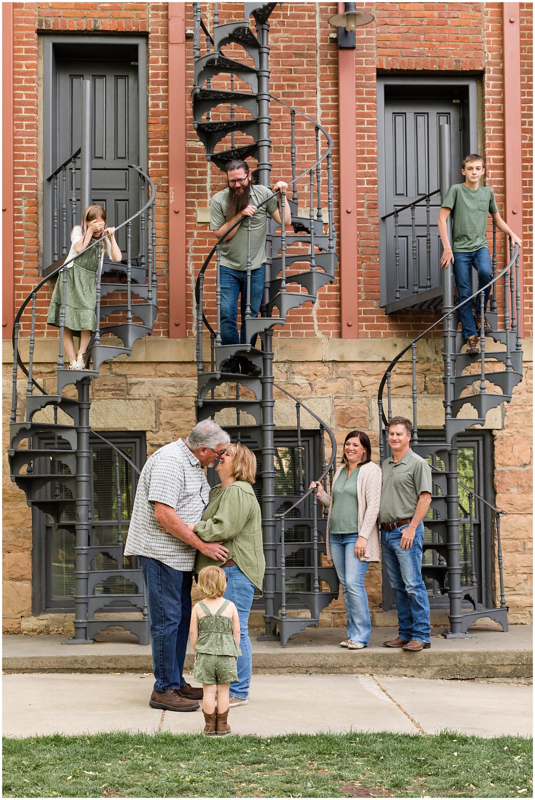 A mother and father celebrating their 38th wedding anniversary kiss in front of their son, daughter, son-in-law, and three grandchildren to mark the occasion