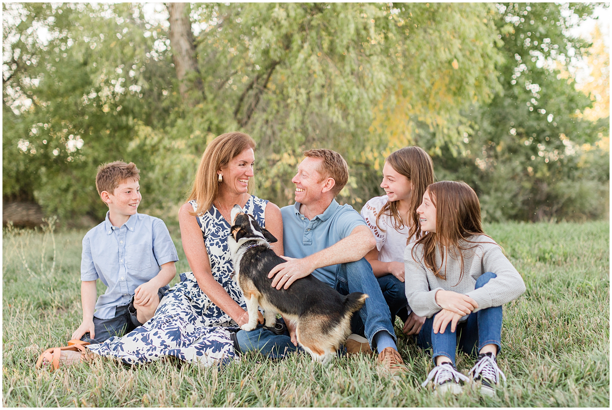 A family of five laugh together as they pose with their corgi during a fall mini session at Thomas Reservoir