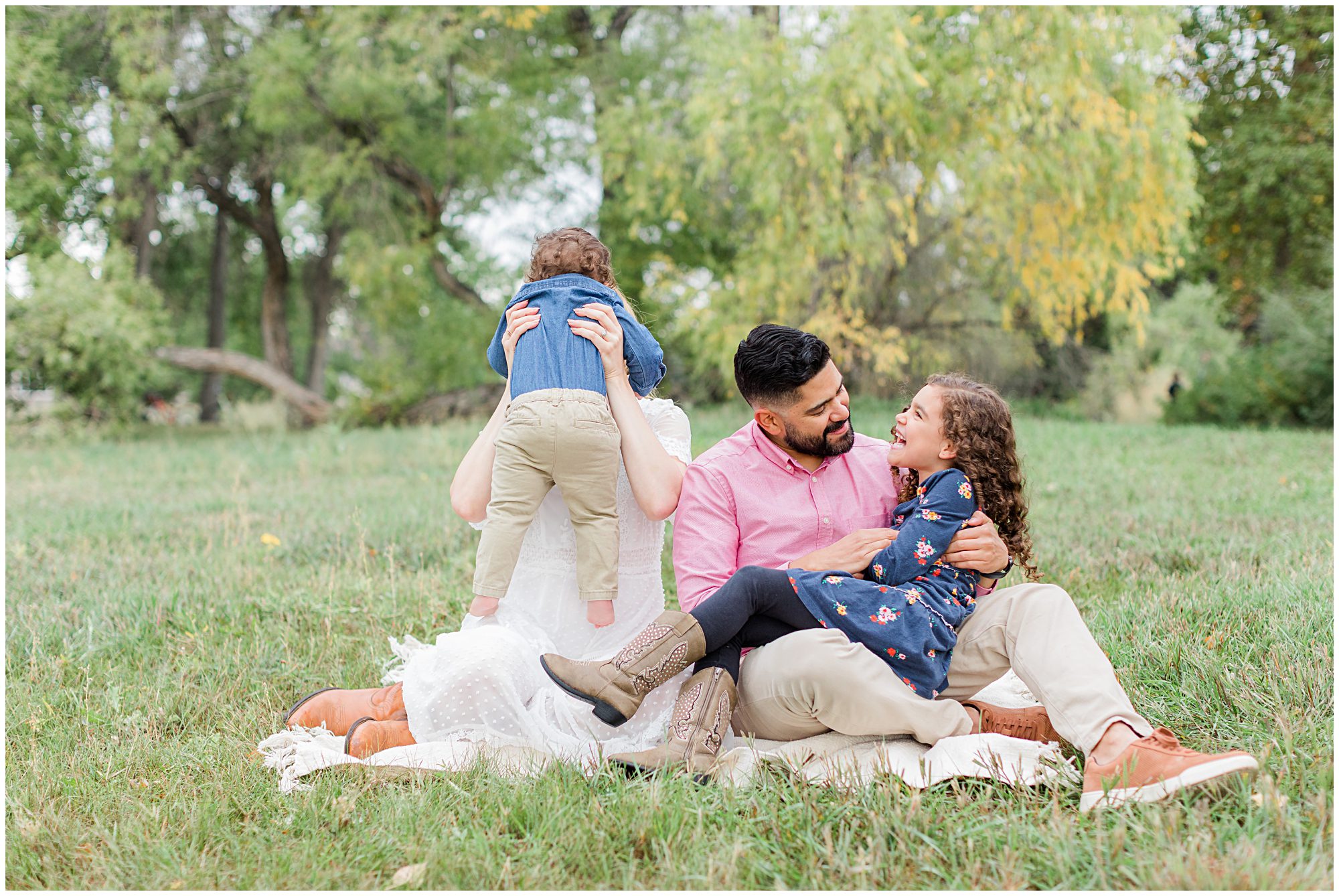 A mother and father laugh and play with their two young children during their fall mini session at Thomas Reservoir