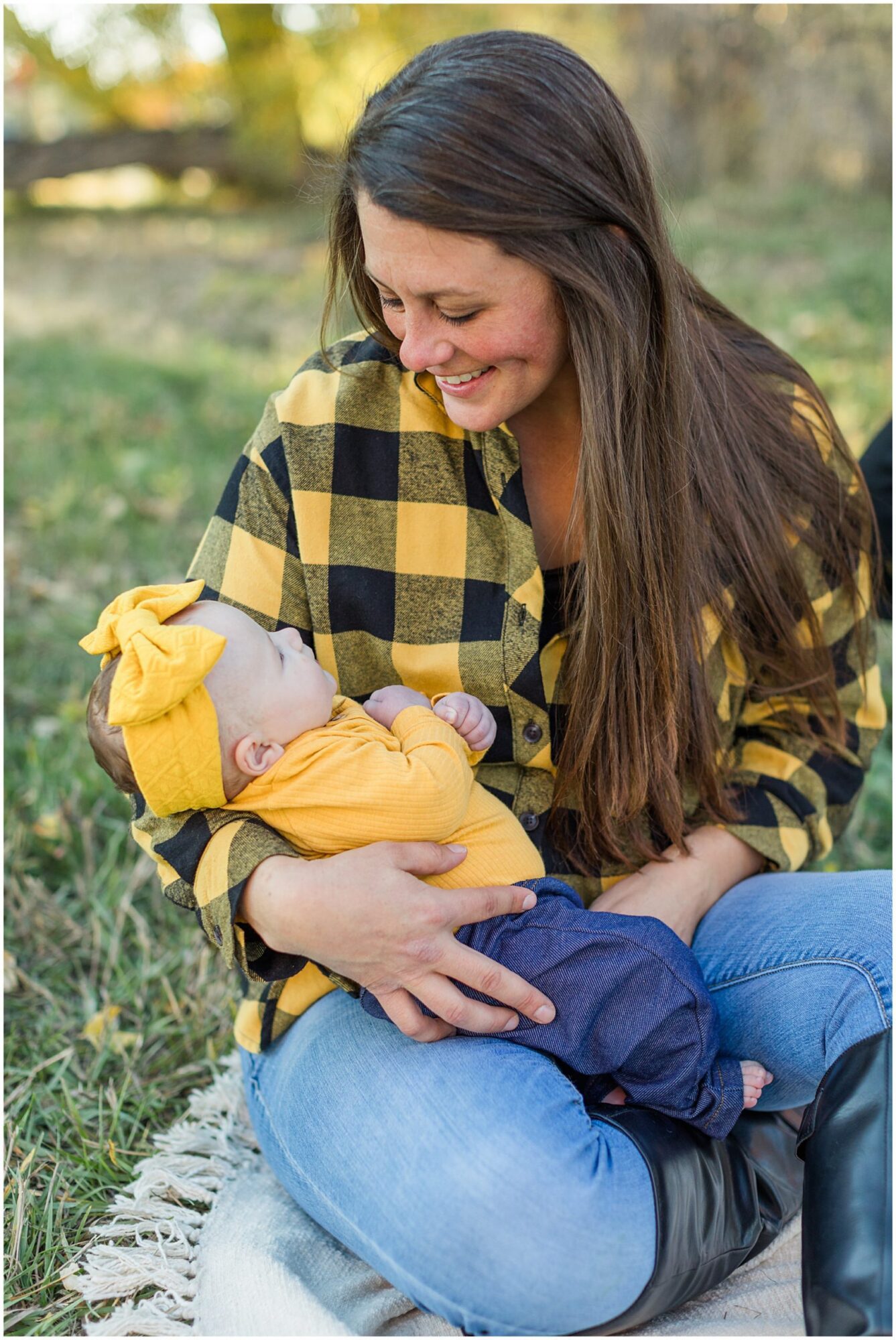 A mother smiles down tenderly at her baby girl cradled in her arms