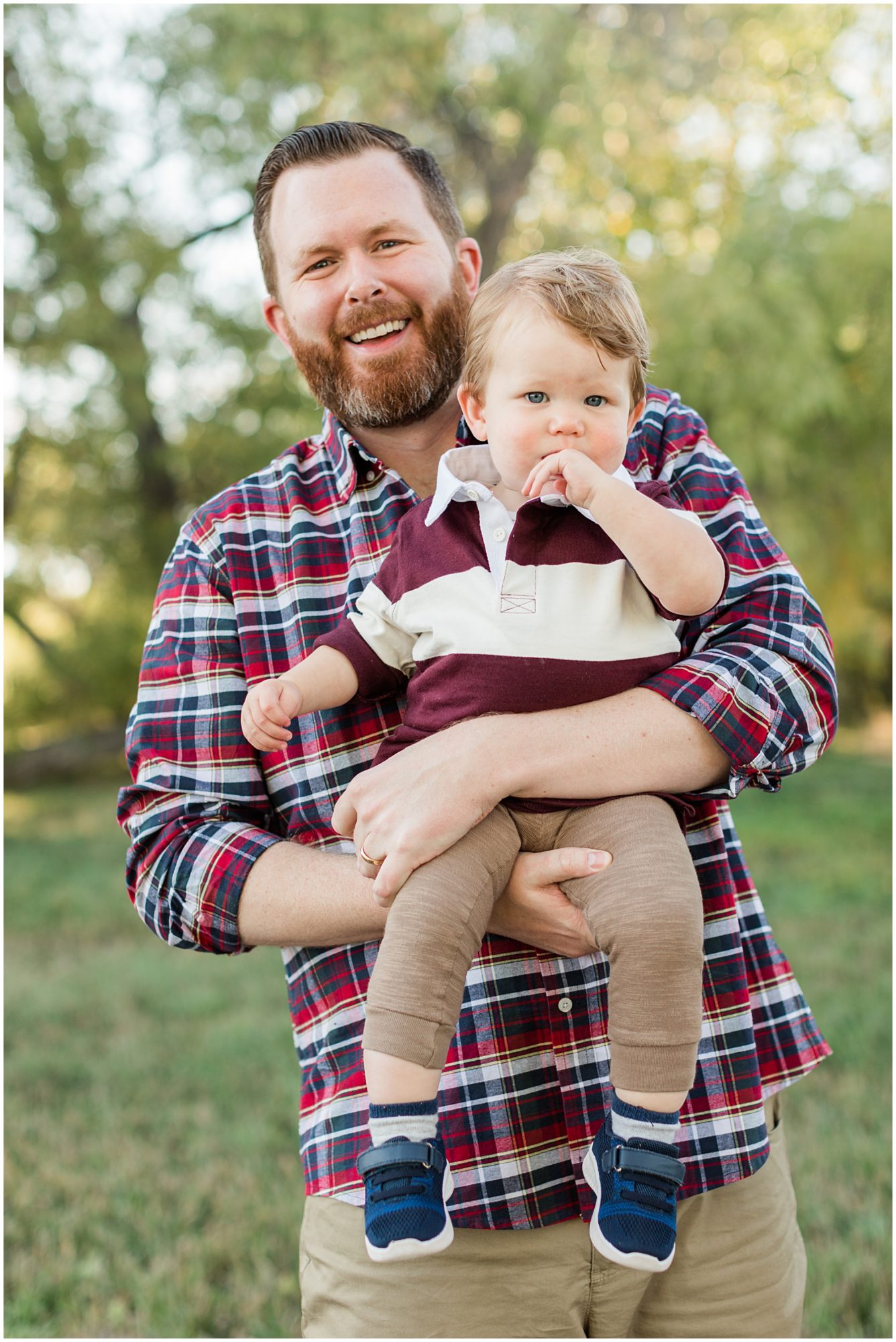 A father cradles his young son as he smiles at the camera during their fall mini session at Thomas Reservoir