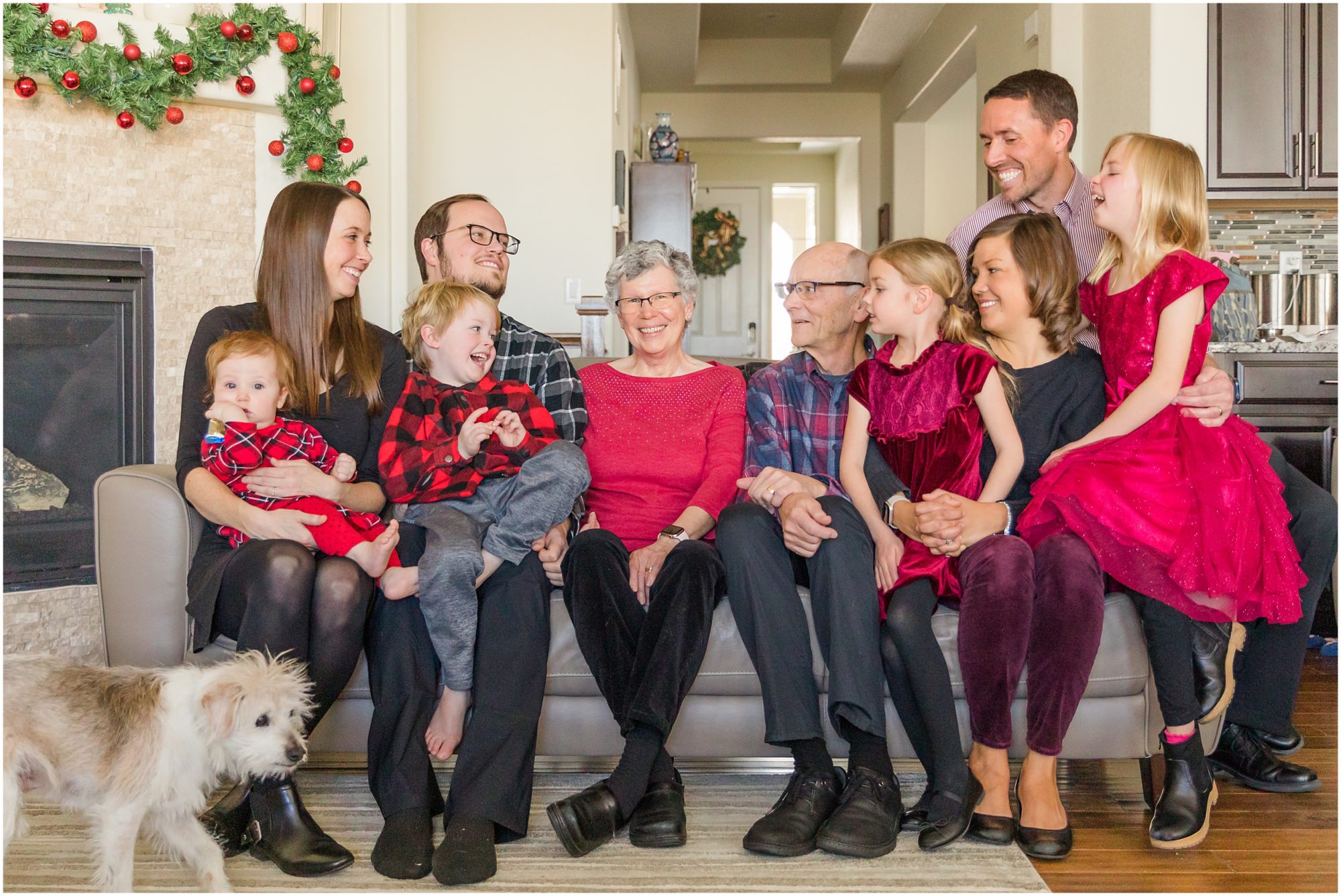 A candid photo captured of grandparents, parents, and grandchildren gathered on their living room sofa.