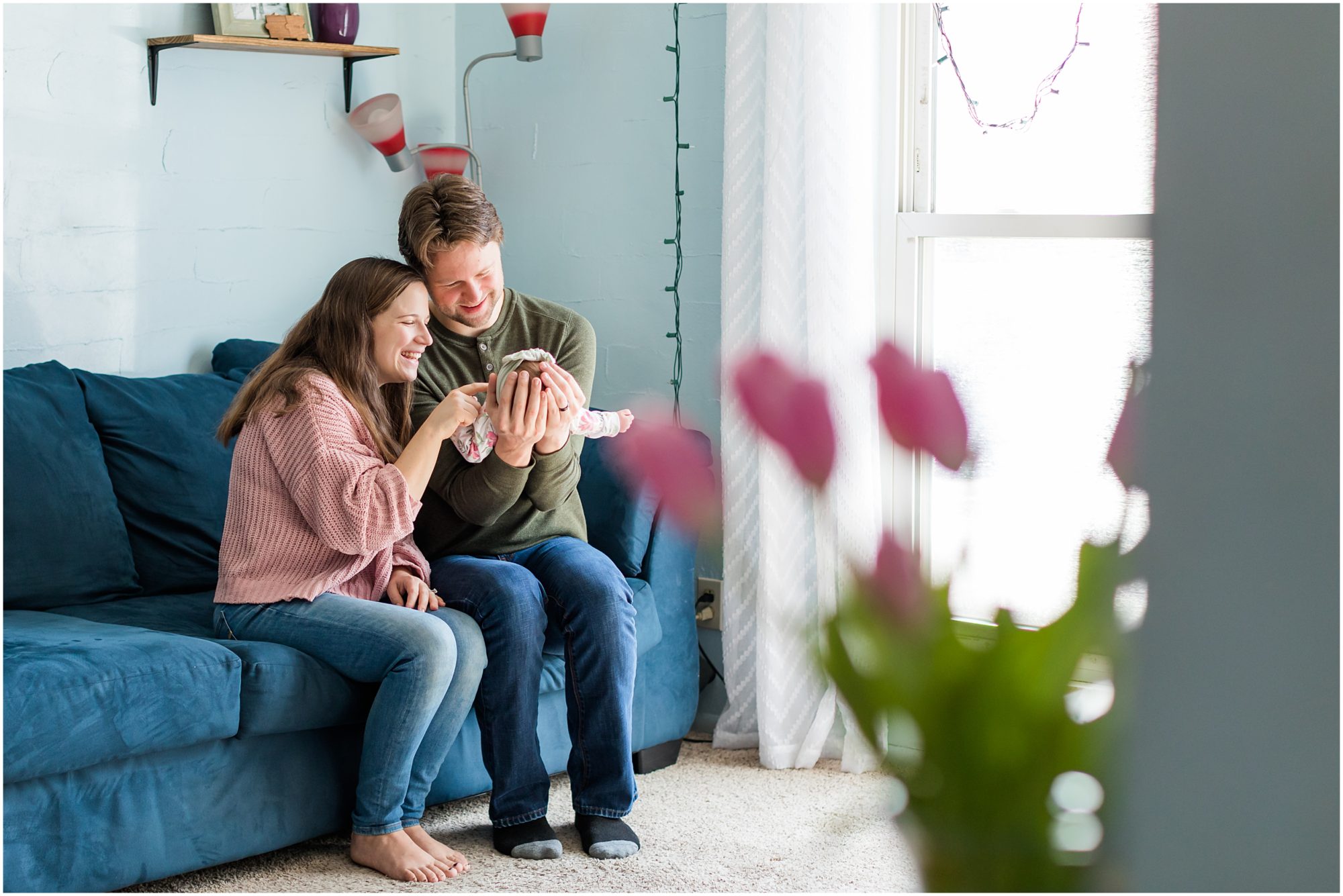 A candid photo of a new mom and dad with their baby girl taken during their in-home newborn session by Theresa Pelser Photography