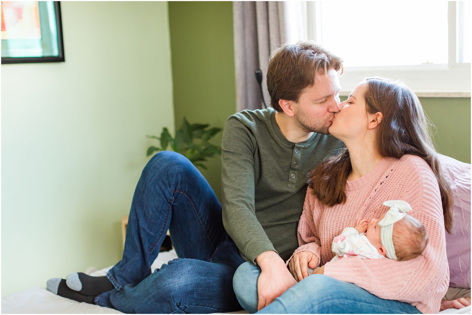 A candid photo of a new mom and dad with their baby girl taken during their in-home newborn session by Theresa Pelser Photography