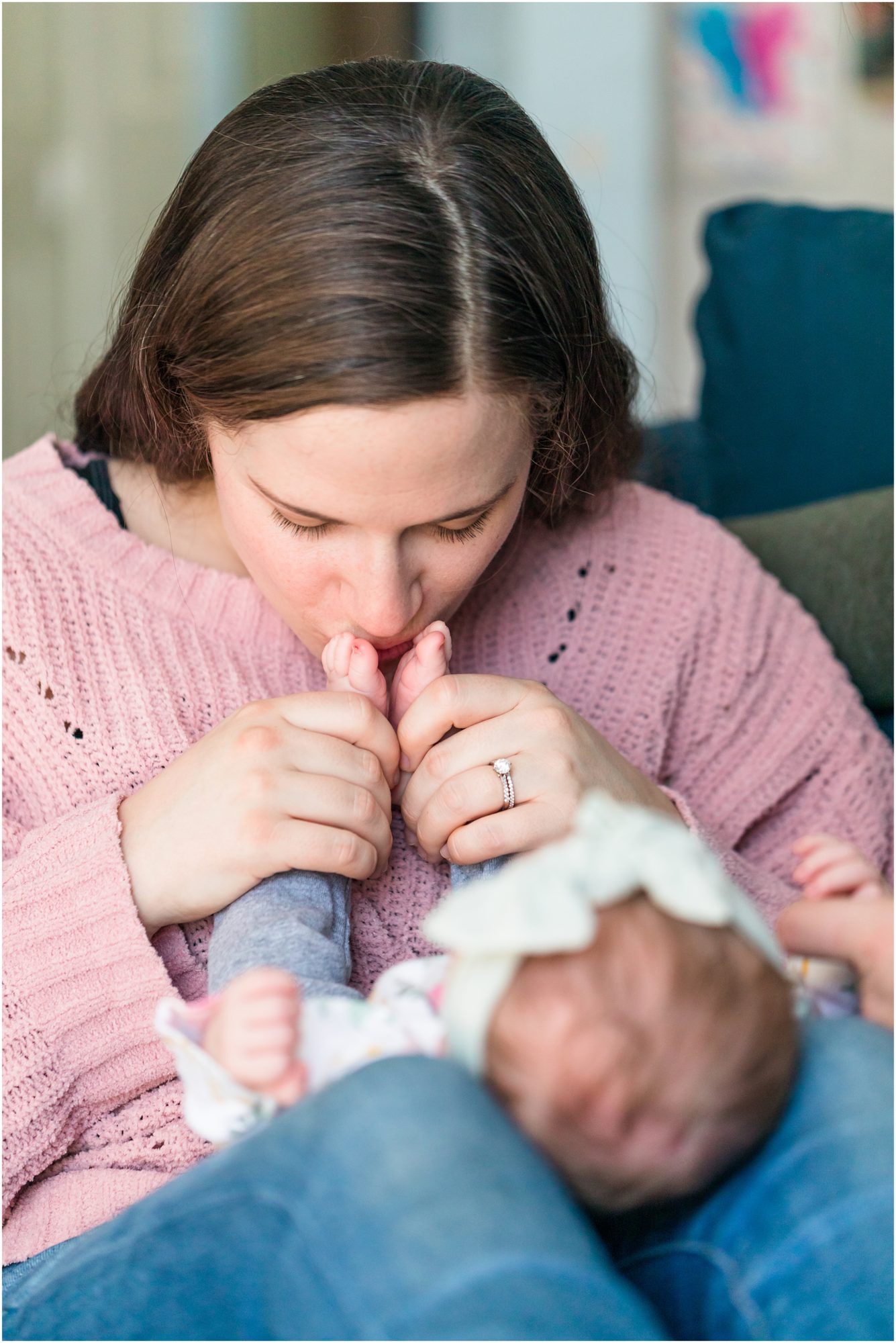 A candid photo of a new mom kissing her baby's feet captured during an in-home newborn session by Theresa Pelser Photography