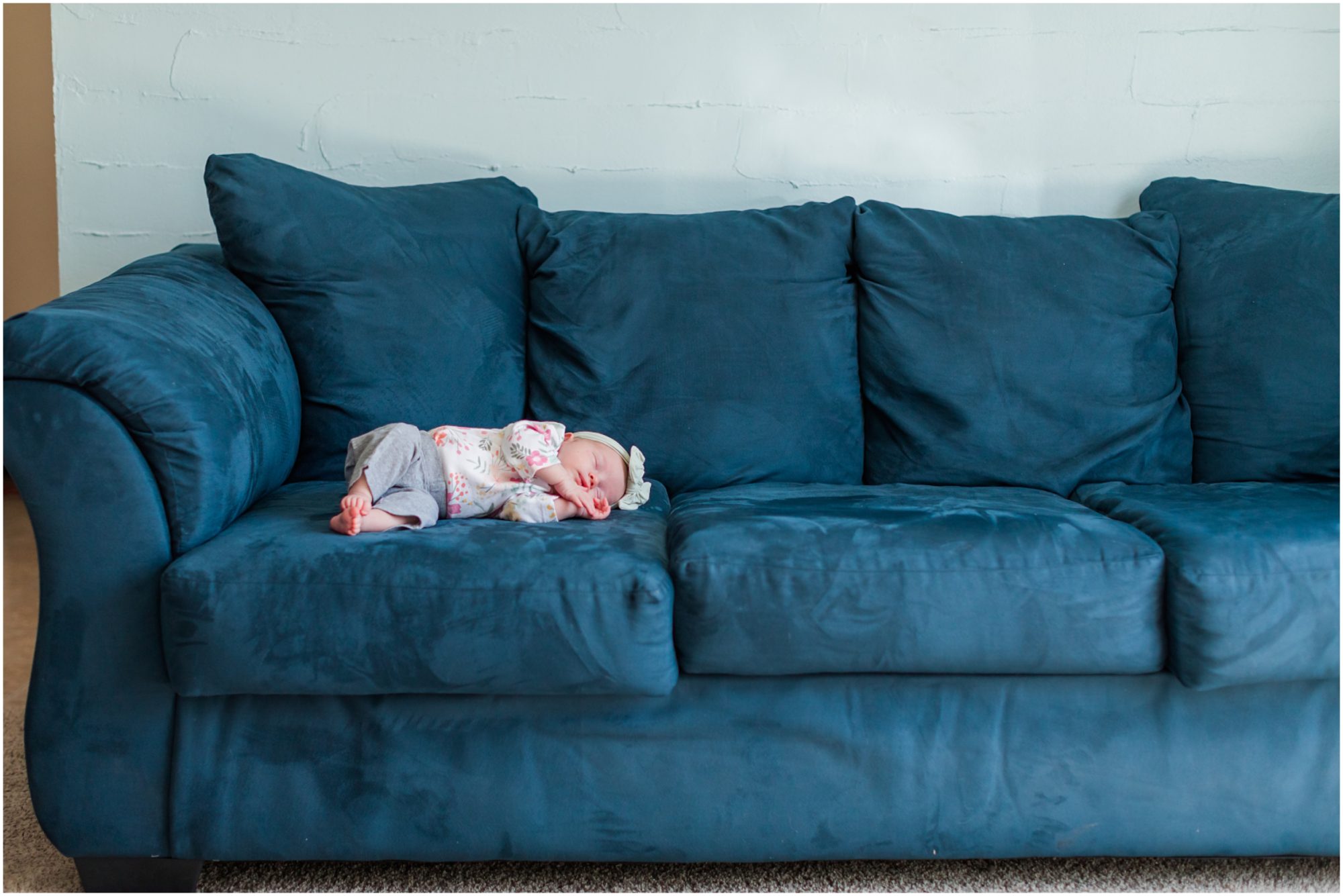 A photo of a baby girl sleeping on a sofa taken during an in-home newborn session by Theresa Pelser Photography