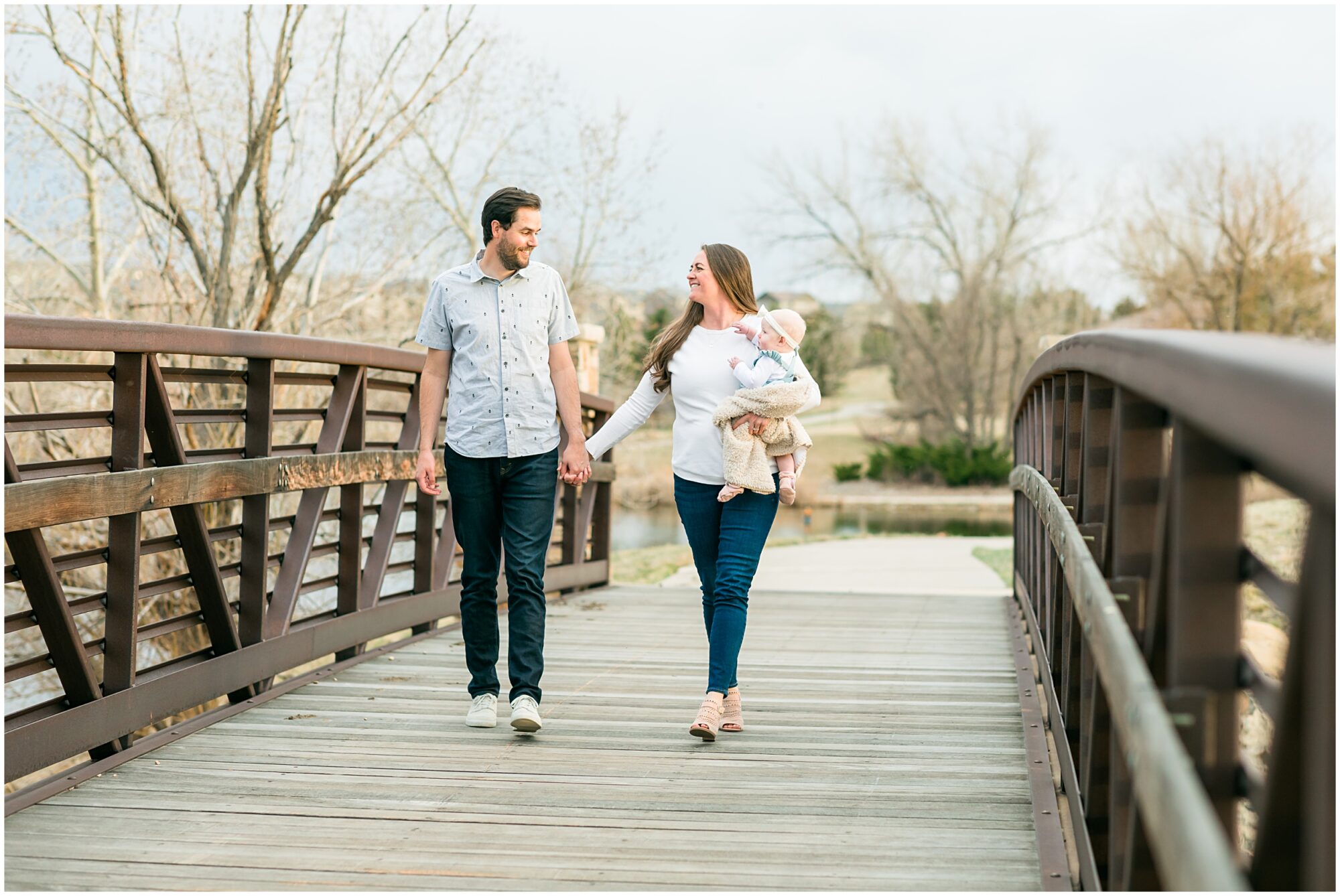 A photo of a family with a baby walking across a bridge captured during their family session with Theresa Pelser Photography