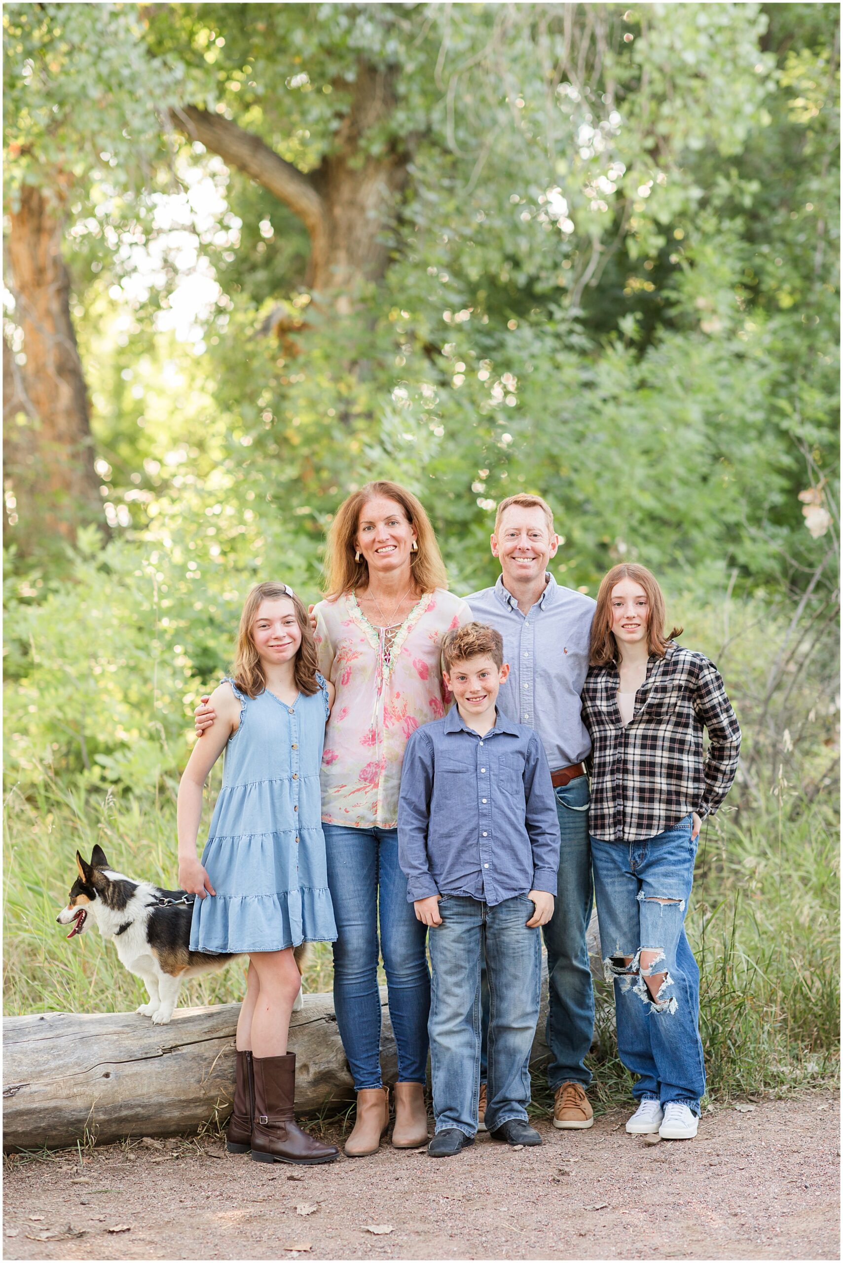 7-VH_Fall-Mini-Sessions_Erie-Family-Photography_091723-0591 Parents standing close and smiling at the camera in front of a light stone wall during their family session in Boulder.