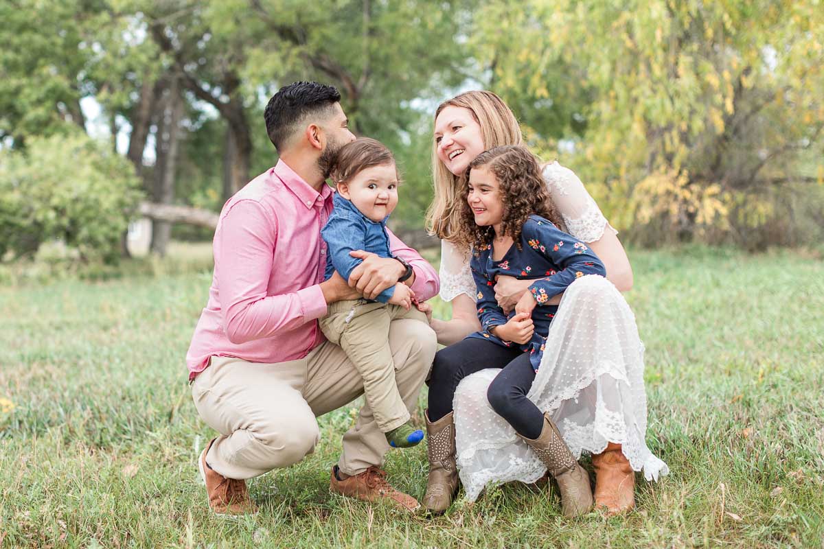 Family of four sharing a happy moment outdoors during a fall family photo session near Erie, Colorado.