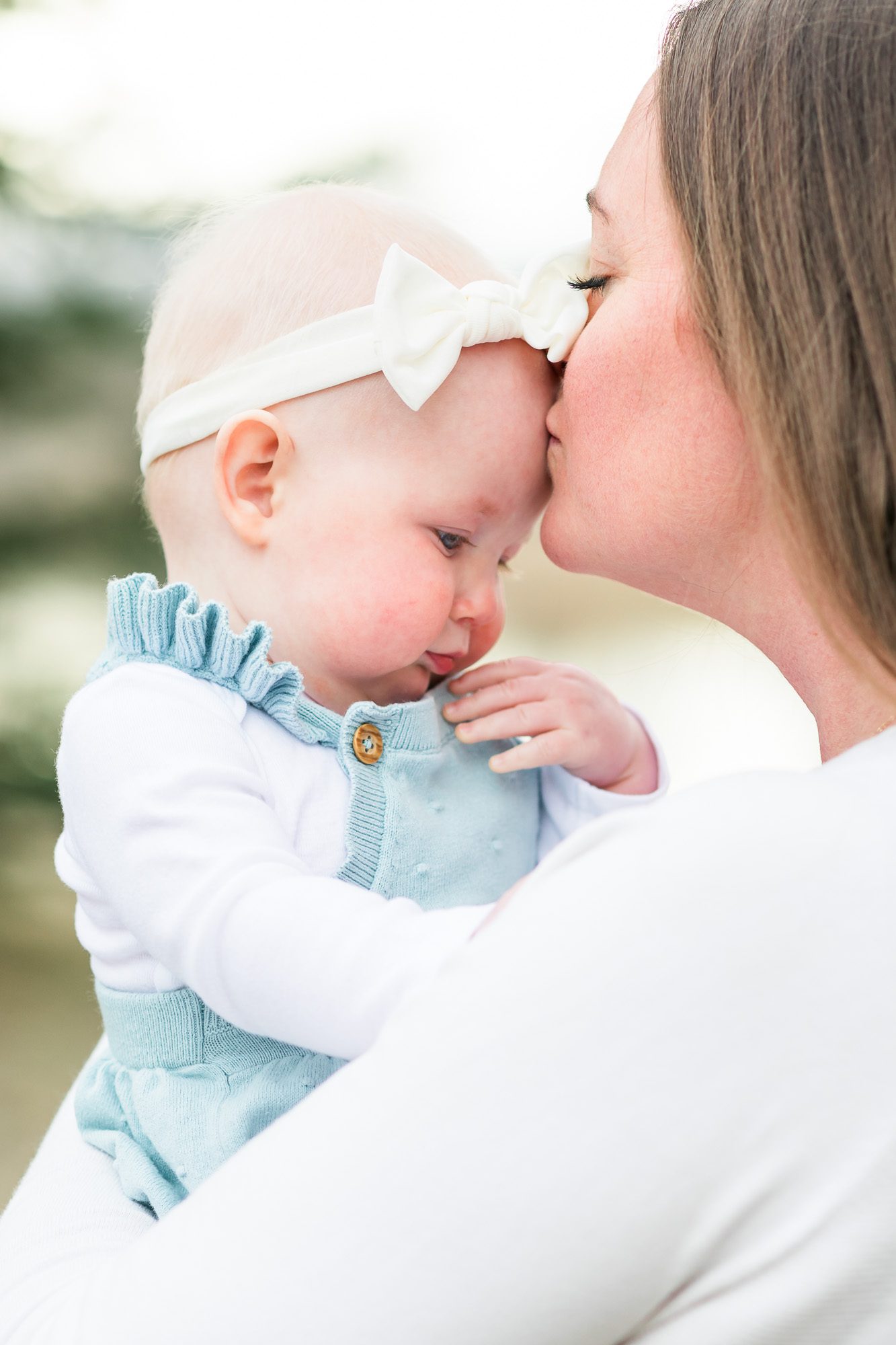 Mother gently kissing her baby’s forehead during a family photo session in Broomfield, Colorado.