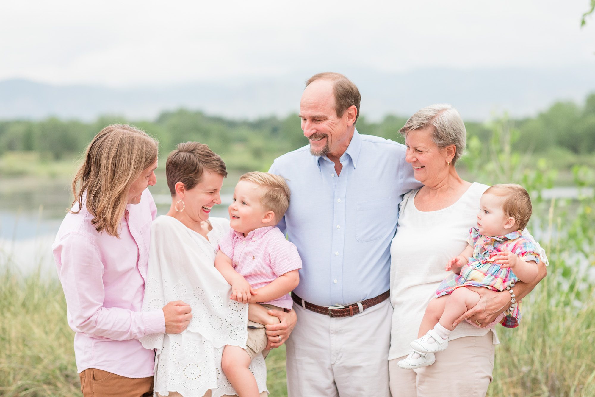 Outdoor extended family portrait with grandparents, parents, and two young children smiling together, captured by an Erie family photographer in Boulder, Colorado.