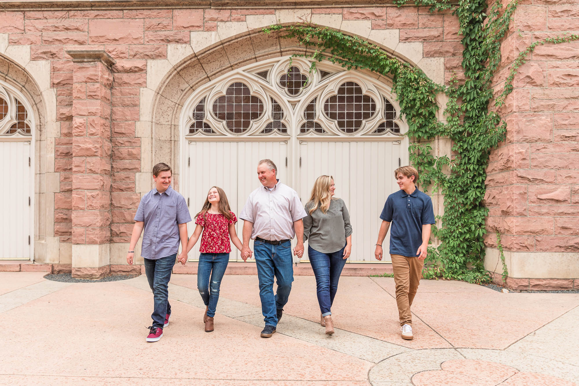 Family of five walking together in front of a historic building, photographed by an Erie family photographer in Boulder, Colorado.