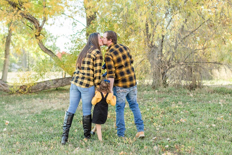 Parents and toddler in mustard and black plaid shirts - layered textures that work well for fall family sessions.