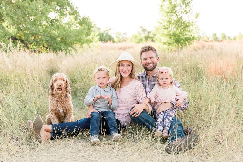 Family of four wearing coordinating pink and grey color pallet with textures and patterns for visual interest during an outdoor fall mini session.