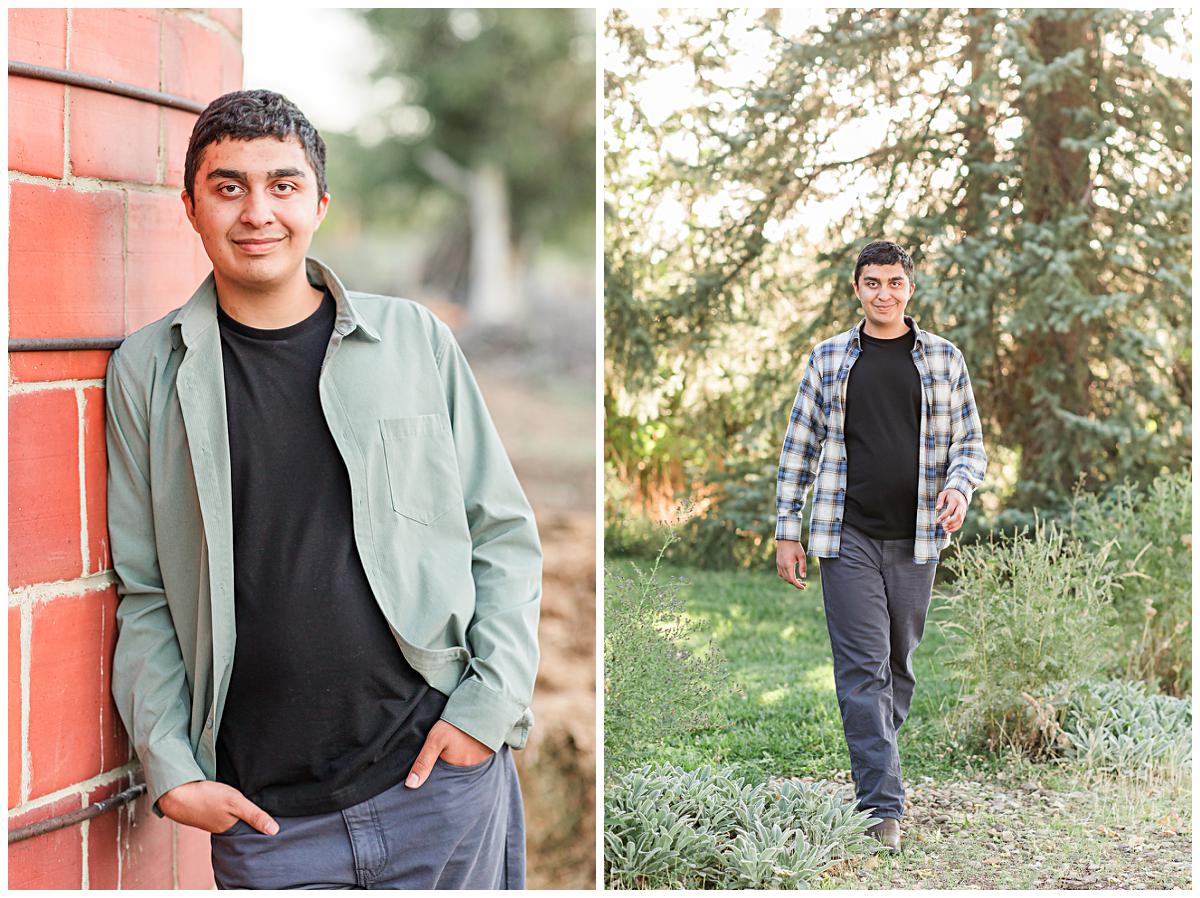 Senior photo of guy in neutral layers and subtle patterns leaning against a brick wall