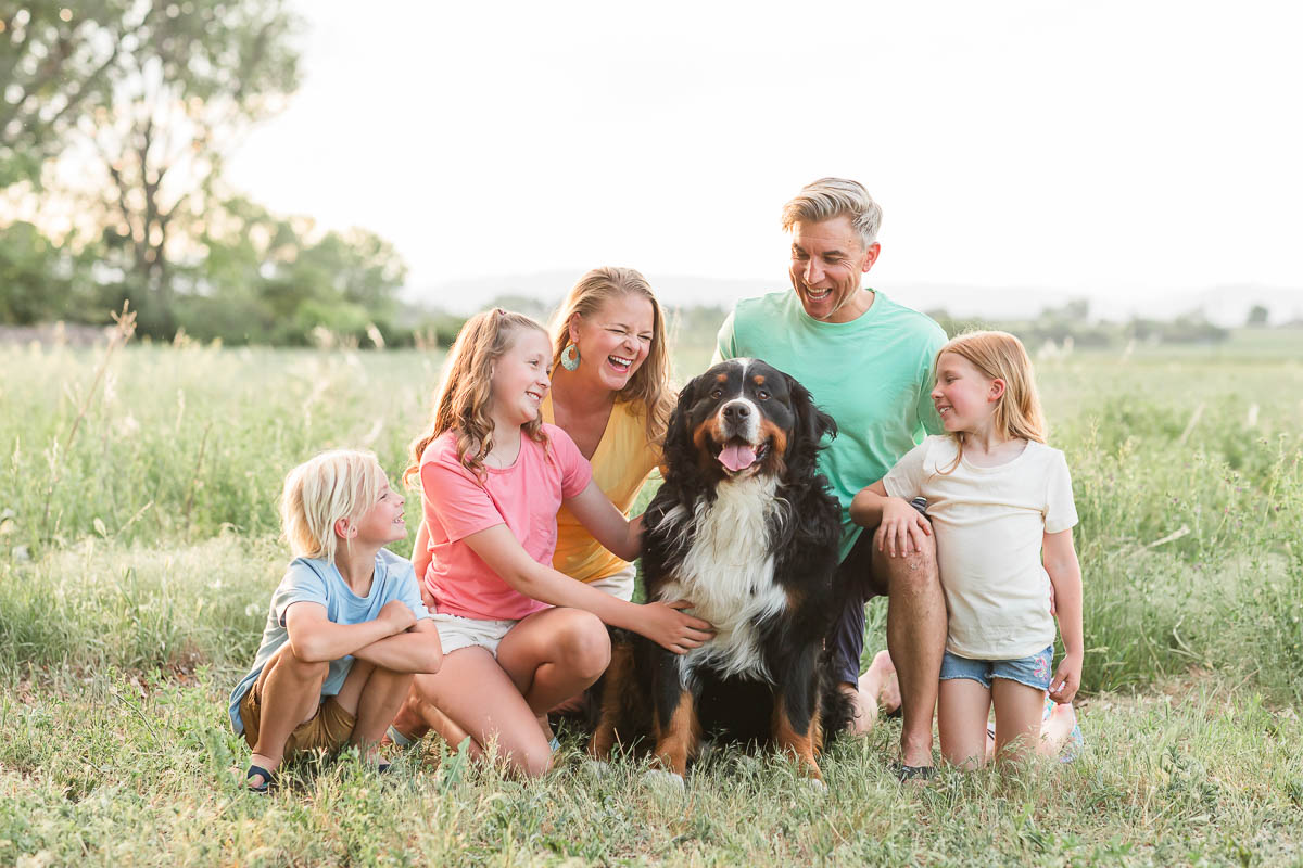 Family of five sitting together with their dog during an outdoor family photo session in Erie, Colorado